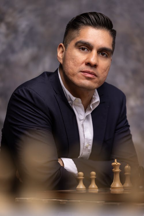 Man in Suit Sitting by Chess