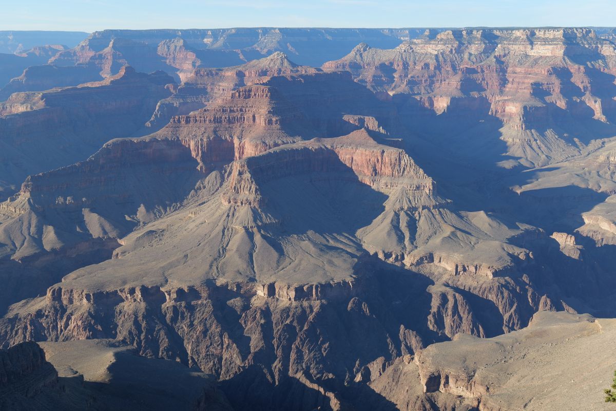 Layered red canyon walls of the Grand Canyon at sunrise