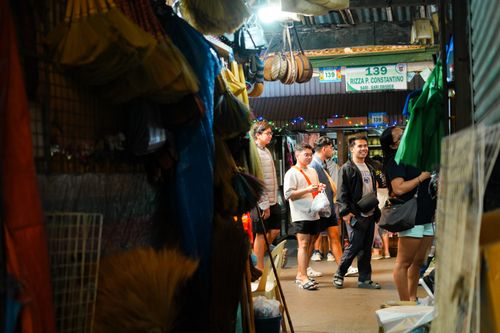 Free A lively market scene with diverse people shopping amidst colorful stalls filled with goods. Stock Photo