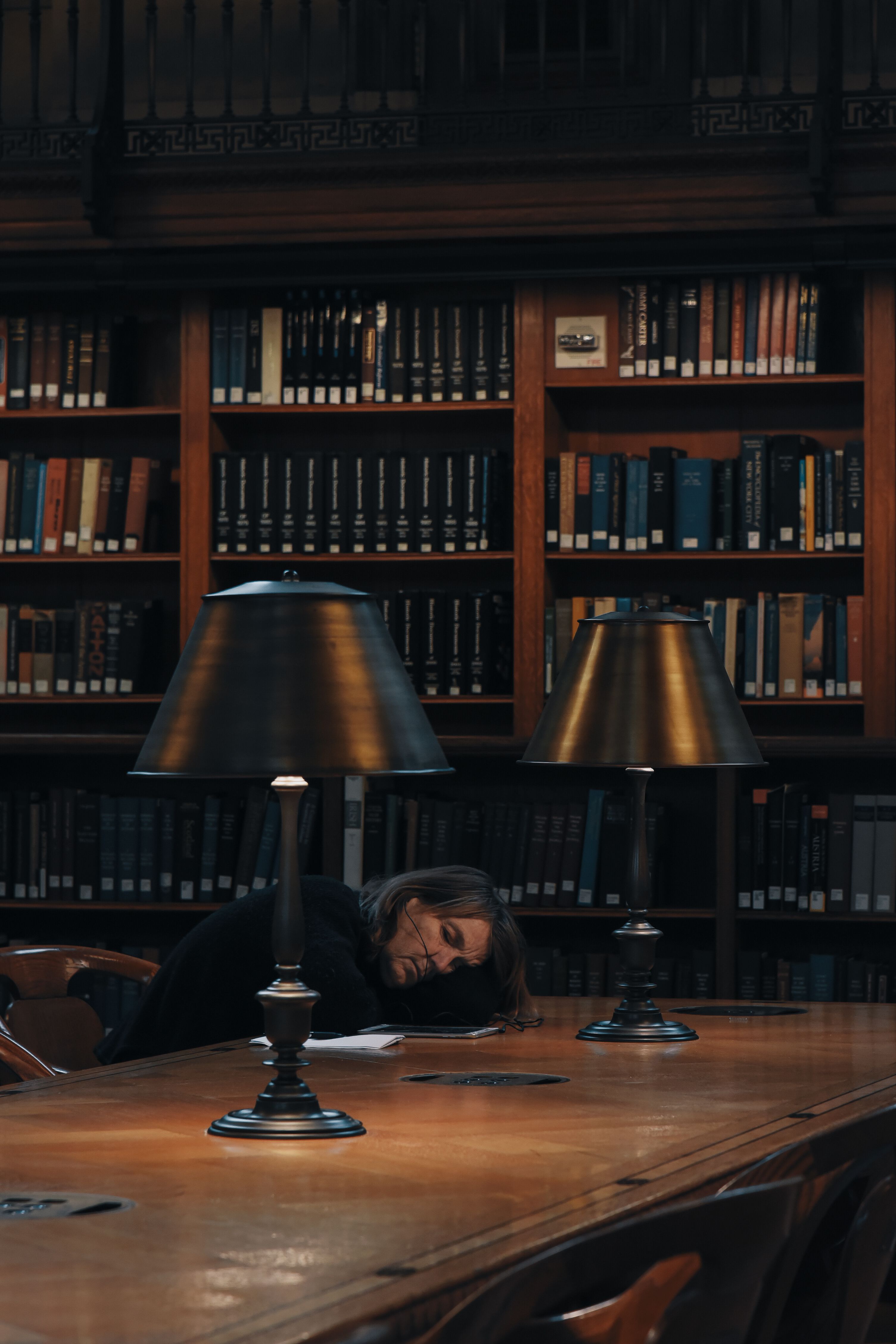 Person Lying Down and Sleeping on Table at Library · Free Stock Photo
