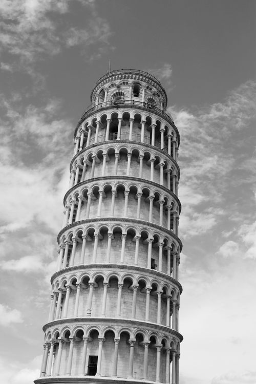 Free Monochrome shot of the iconic Leaning Tower of Pisa under cloudy skies. Stock Photo