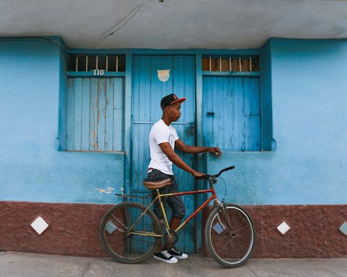 Man with Mountain Bike in Front of Blue Door