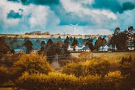 在风景如画的村庄，风力涡轮机矗立于秋叶与戏剧性的天空之下