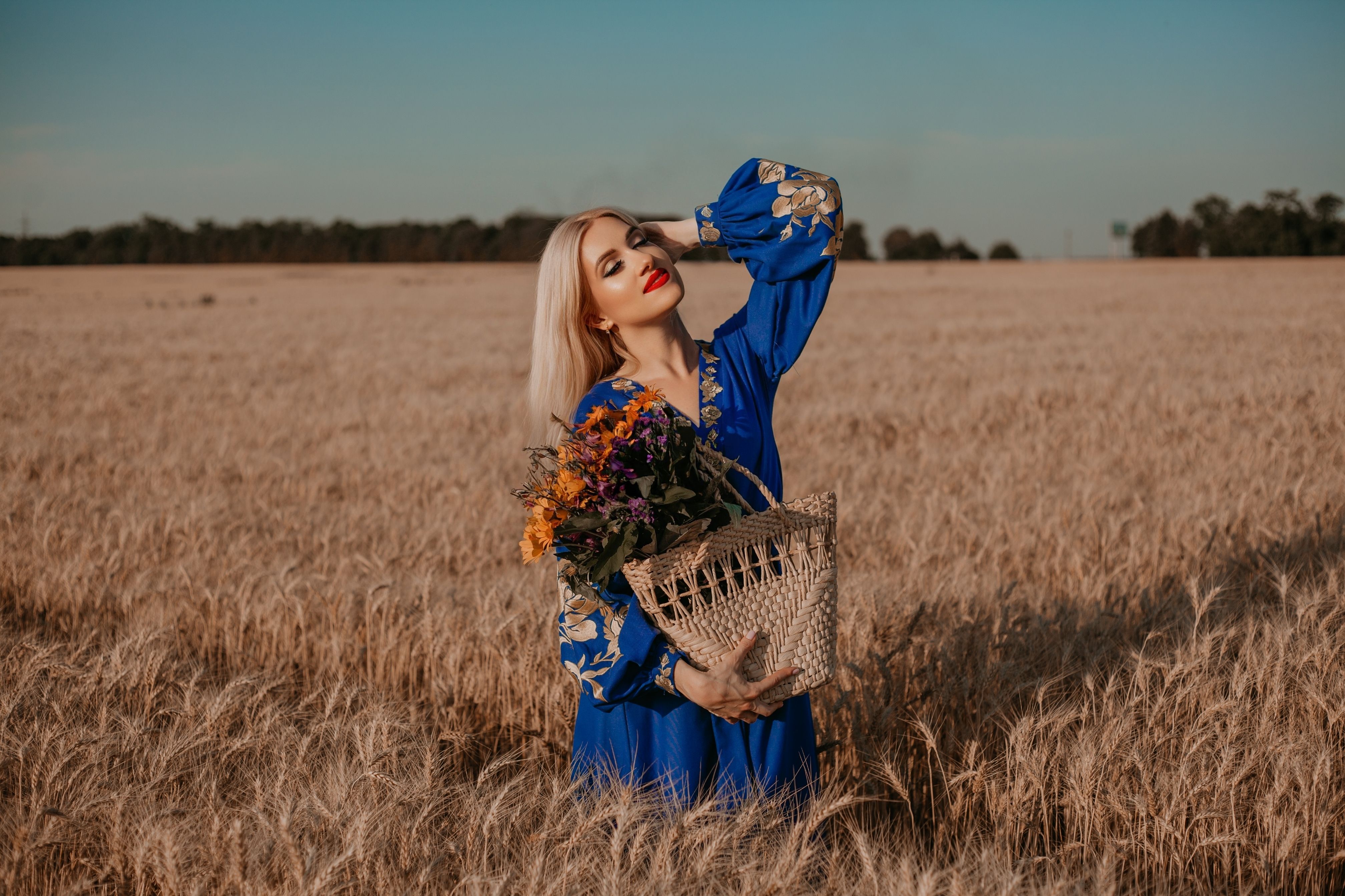 A woman in a blue dress holding a bouquet of flowers · Free Stock Photo
