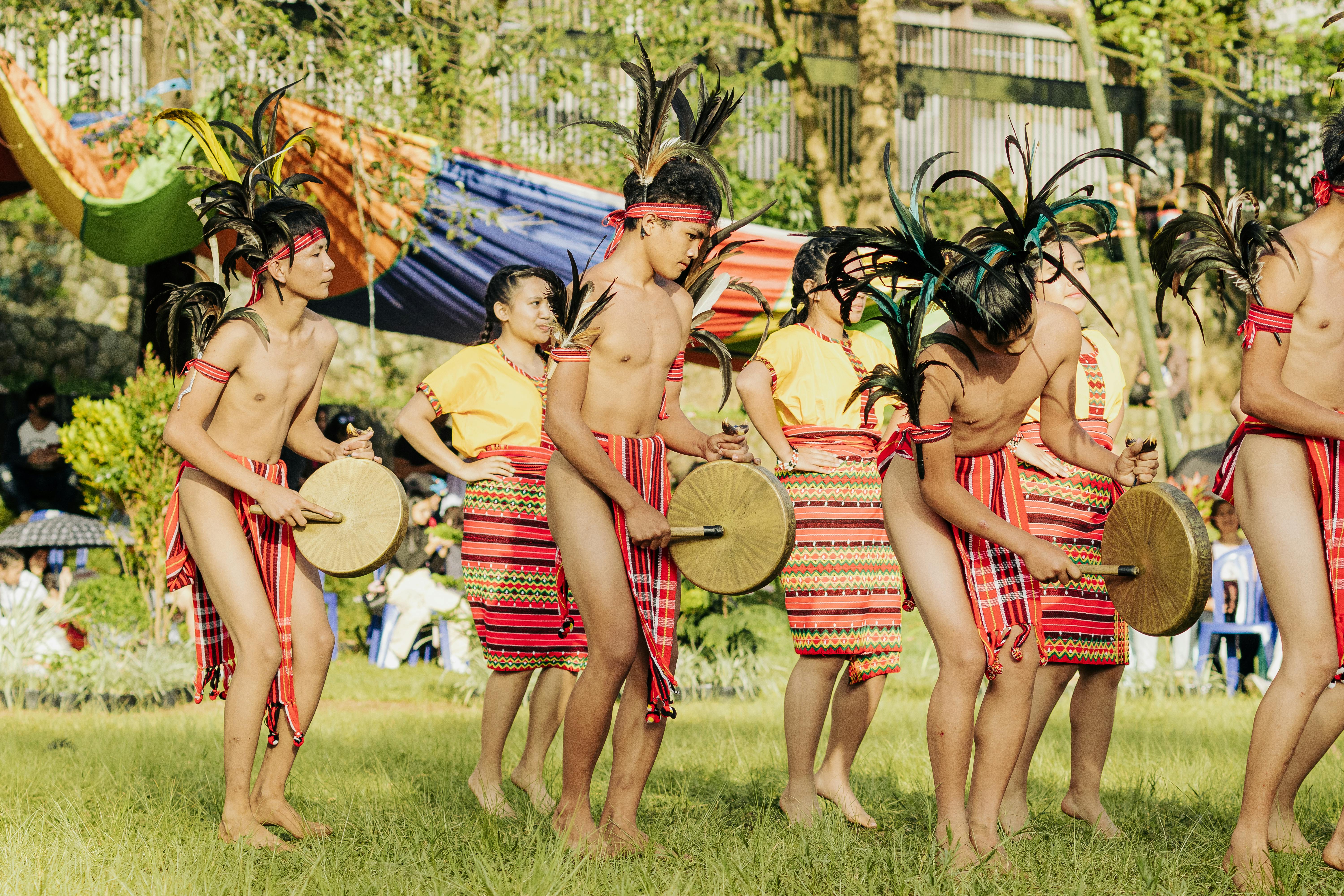Performers in Traditional Costumes Beating the Rhythm on Brass Gongs