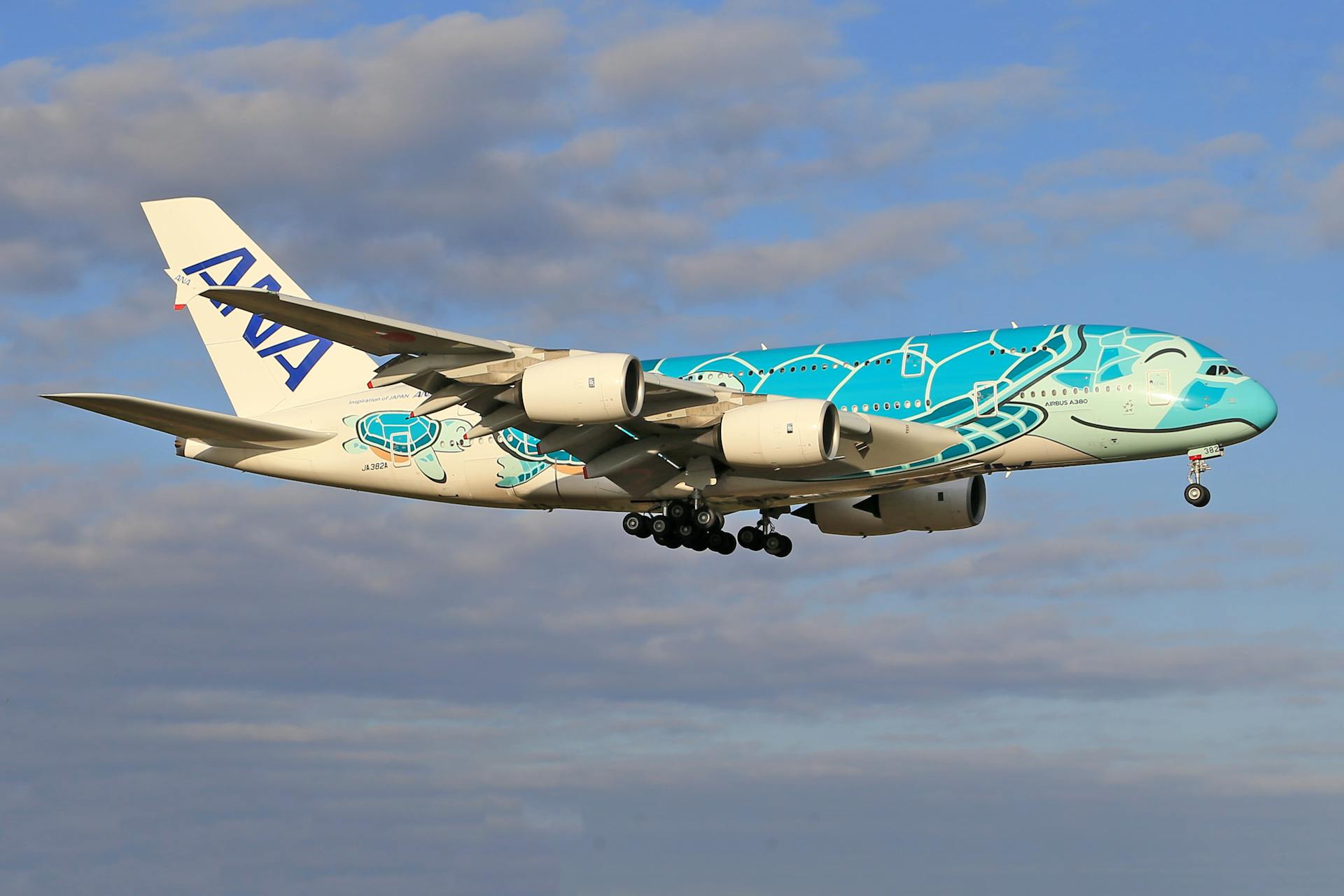 Colorful ANA Airbus A380 in flight against a blue sky, showcasing its unique livery design.