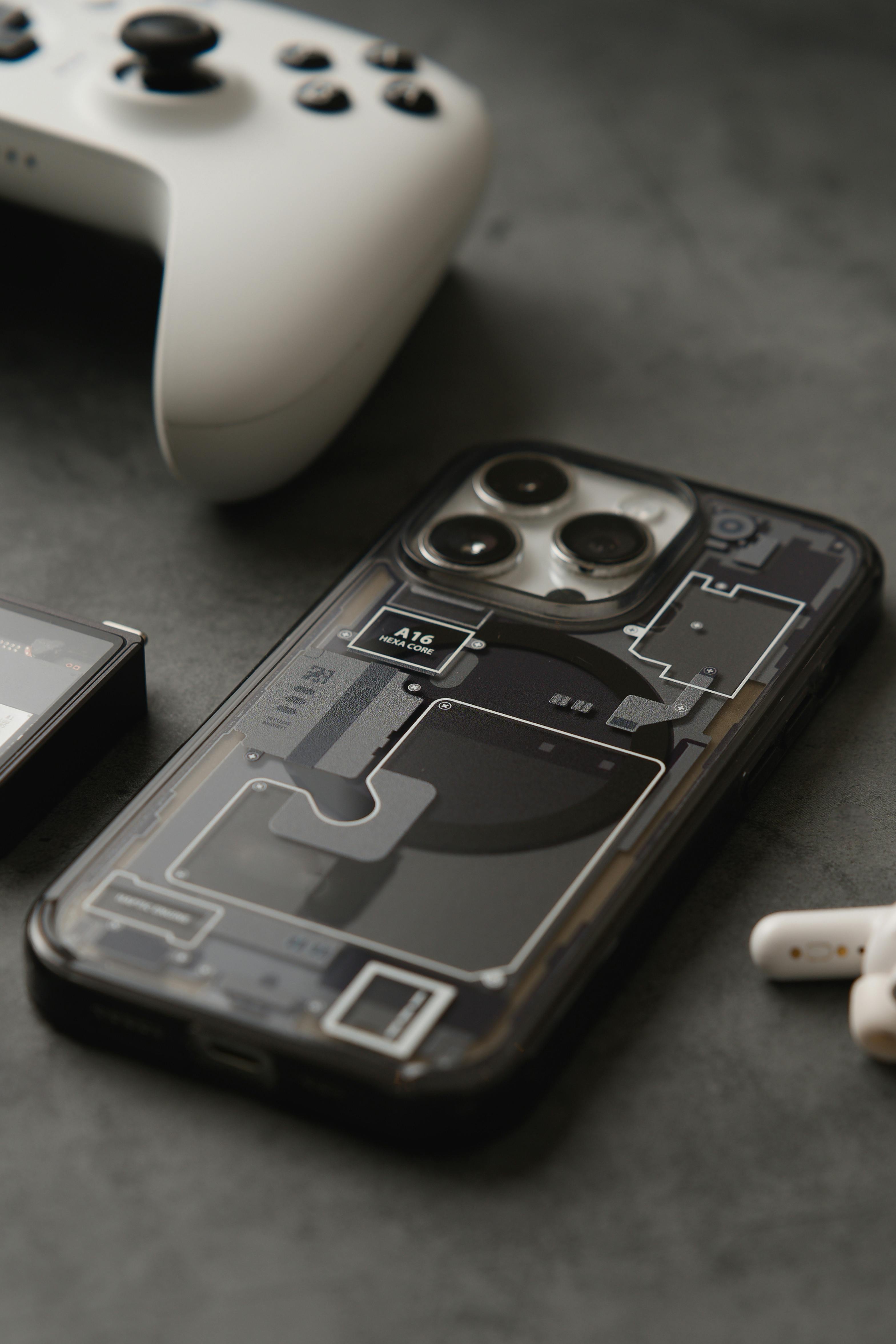 A sleek smartphone with a transparent case alongside a gaming controller, perfect for tech enthusiasts.