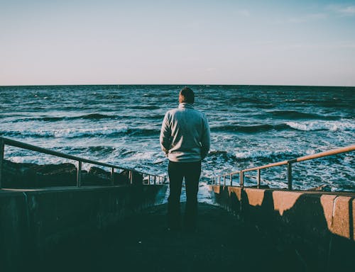 Man Walking on Stairs Near Ocean