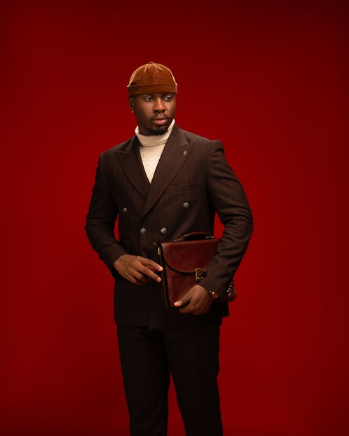 Elegant Man in a Suit Posing in Studio on Red Background 