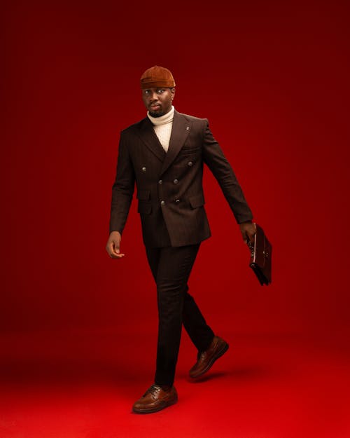 Elegant Man in a Suit Posing in Studio on Red Background 