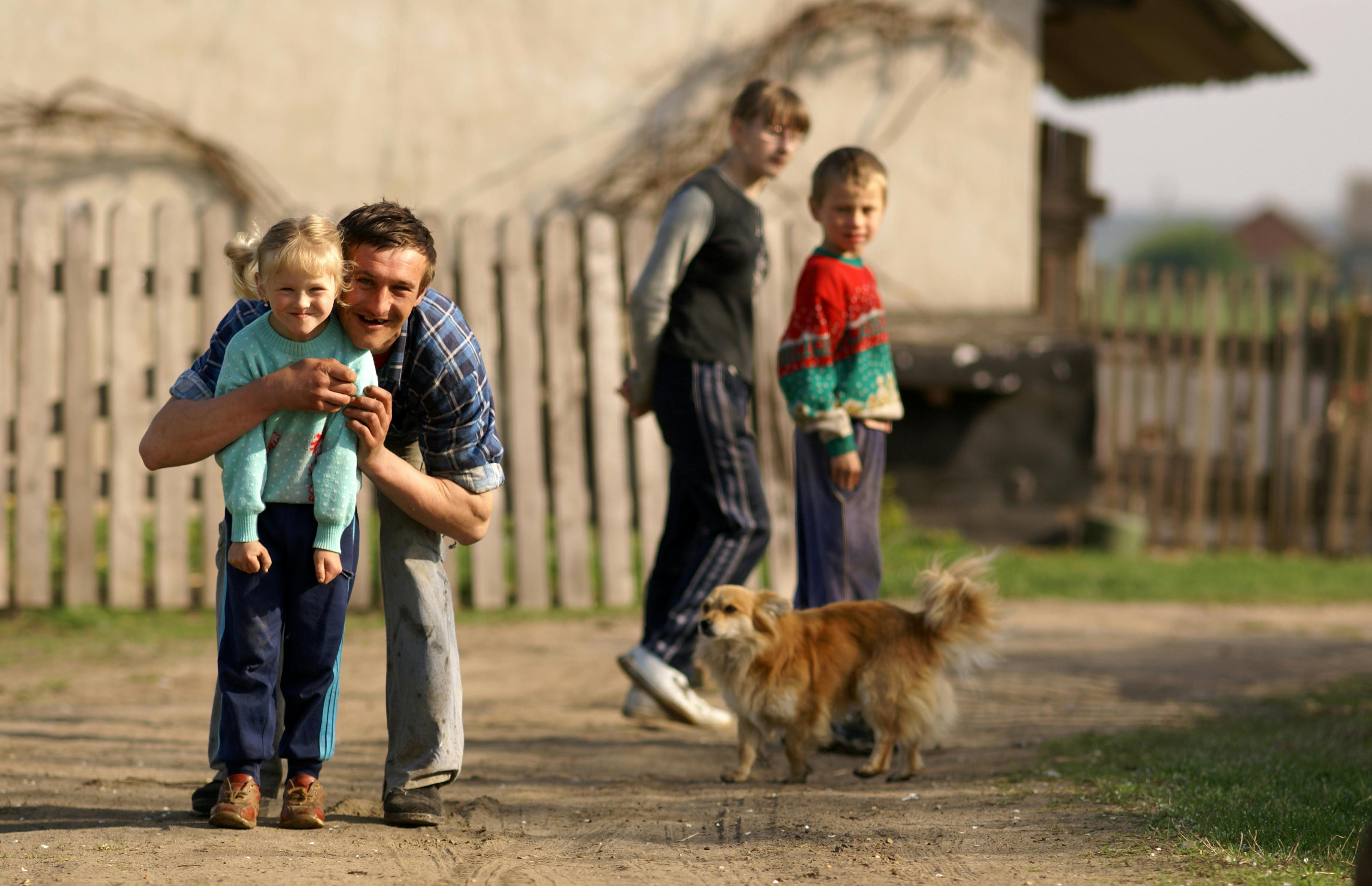 a man and two children are walking with a dog