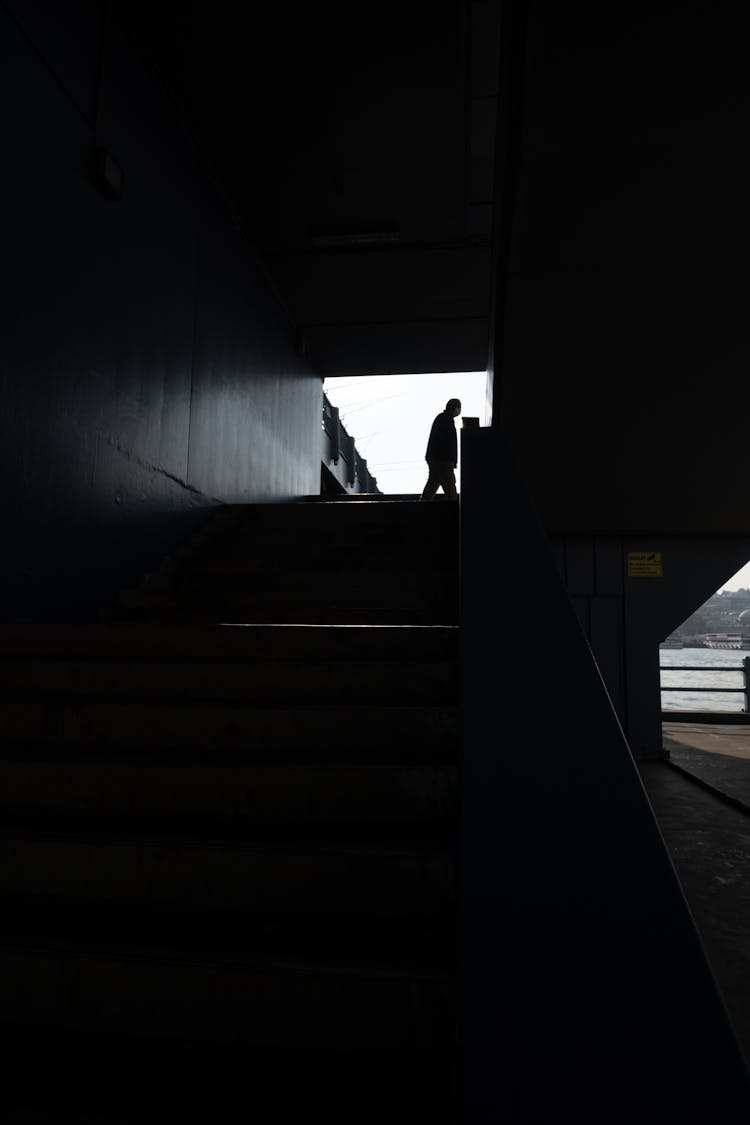 Silhouette Of A Man Walking In A Dark Pedestrian Passage In City 