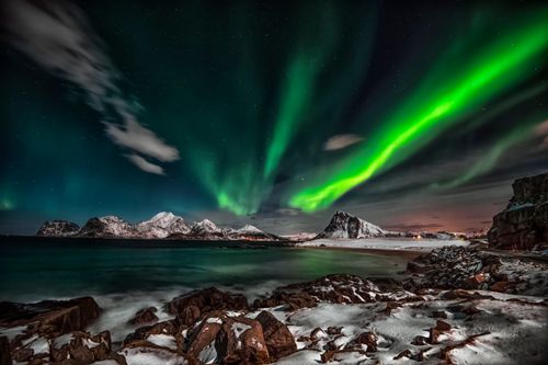 Free Captivating view of the Northern Lights over snow-covered Lofoten Islands at night. Stock Photo