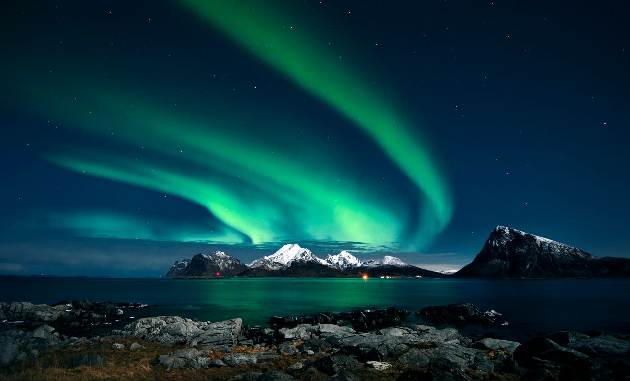 breathtaking northern lights display over snow covered mountains and s