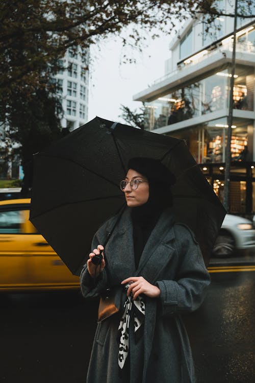 Woman in Dark Woolen Coat Standing under Black Umbrella