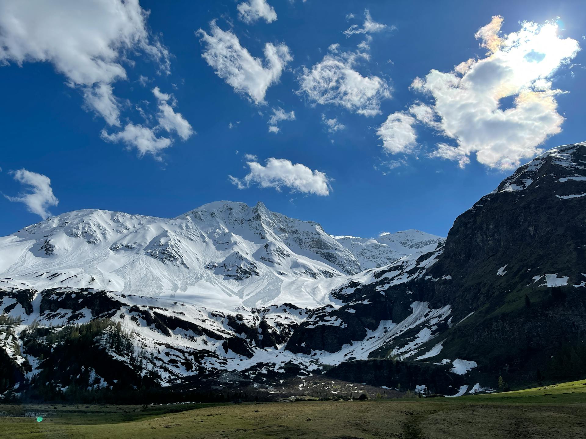 Picturesque snowy mountains under a bright blue sky in Zell am See, Austria.