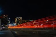 夜晚长时间停留在城市街道上，可以看到动态的交通信号灯小径和点亮的建筑物