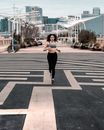 一位穿着运动服的女人正在城市小路上慢跑，展现了城市健身生活方式