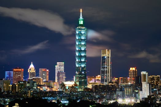 A vibrant night view of Taipei with the illuminated Taipei 101 and surrounding skyline.