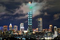 台北101为戏剧性的城市景观增色，在夜晚充满活力的摩天大楼群中格外醒目