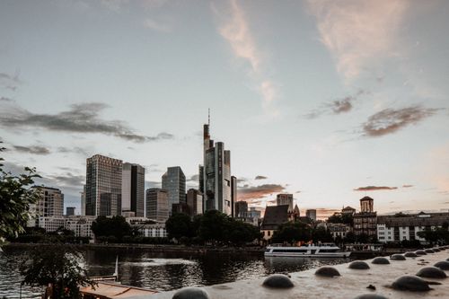 Free Frankfurt's modern skyline reflected in river at sunset, Germany. Stock Photo