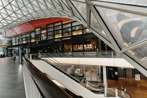 Free Interior view of a modern shopping mall featuring a striking glass ceiling and multiple floors. Stock Photo