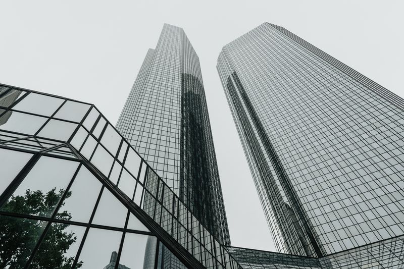Low-angle view of modern skyscrapers with glass facades in an urban setting, showcasing contemporary architecture.