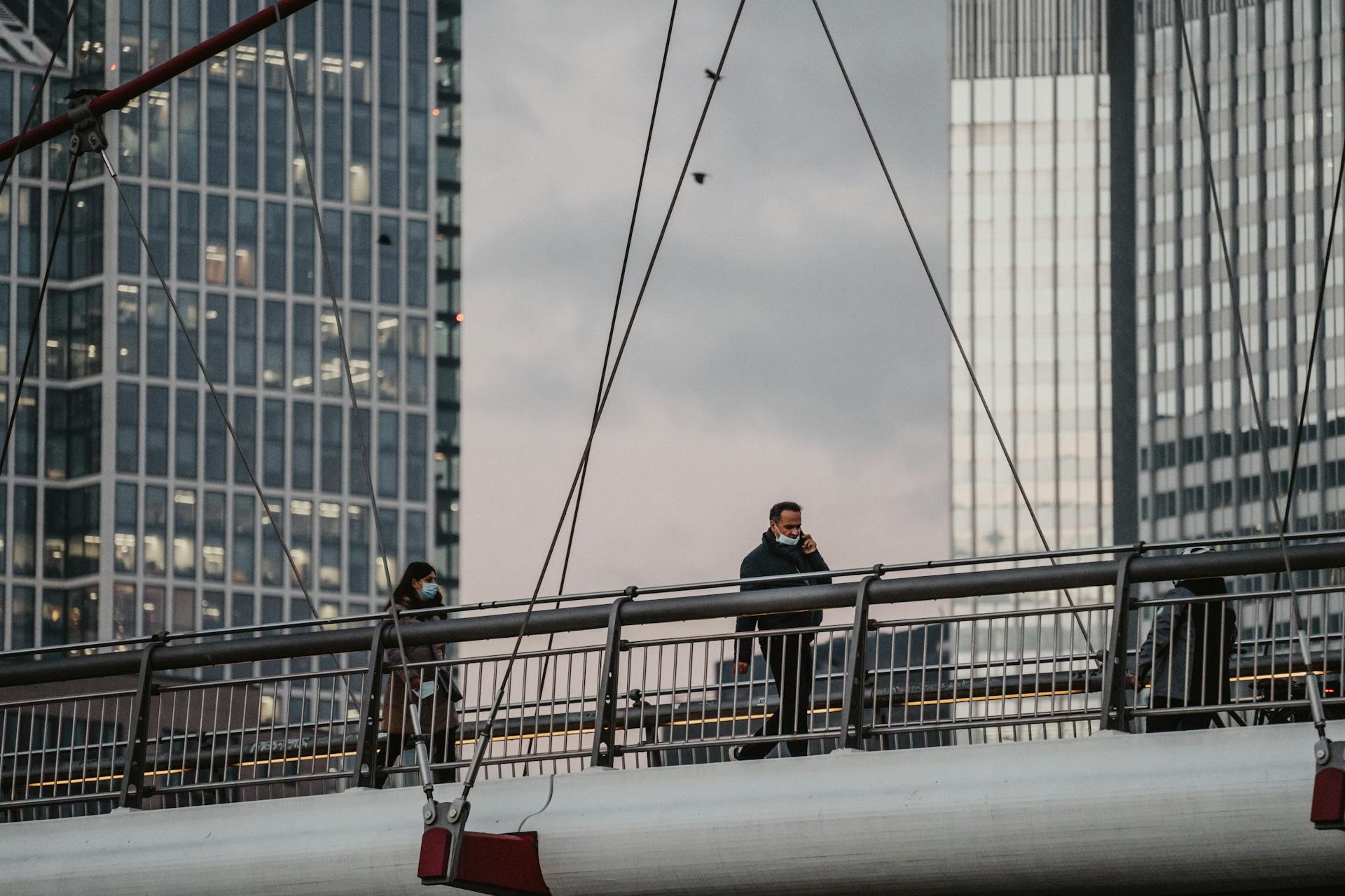 Passersby on a Suspension Footbridge Over a Main River in Frankfurt