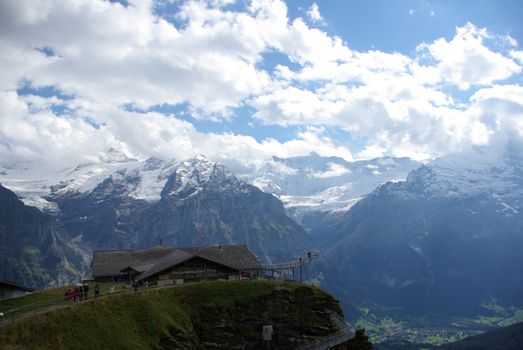 Breathtaking view of the Swiss Alps with a mountain lodge in Grindelwald, Switzerland.