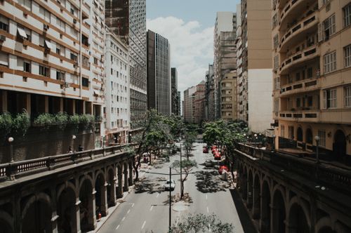 Free View of a vibrant city street flanked by skyscrapers and vintage architecture. Stock Photo