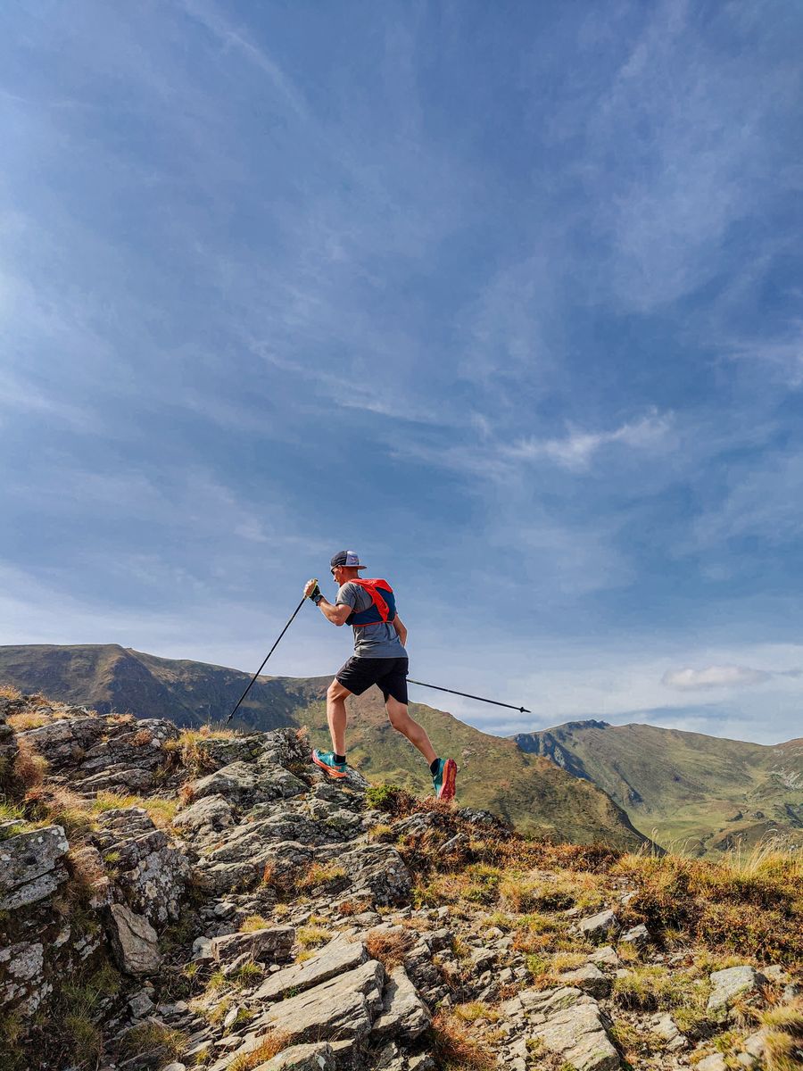 Túrázó trekkingbotokkal sziklás hegyi terepen