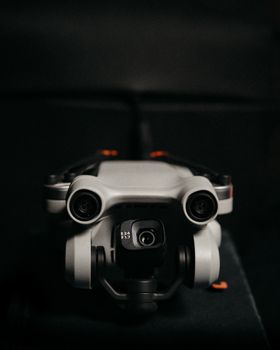 Close-up of a drone camera lens in focus against a dark background, emphasizing technology.