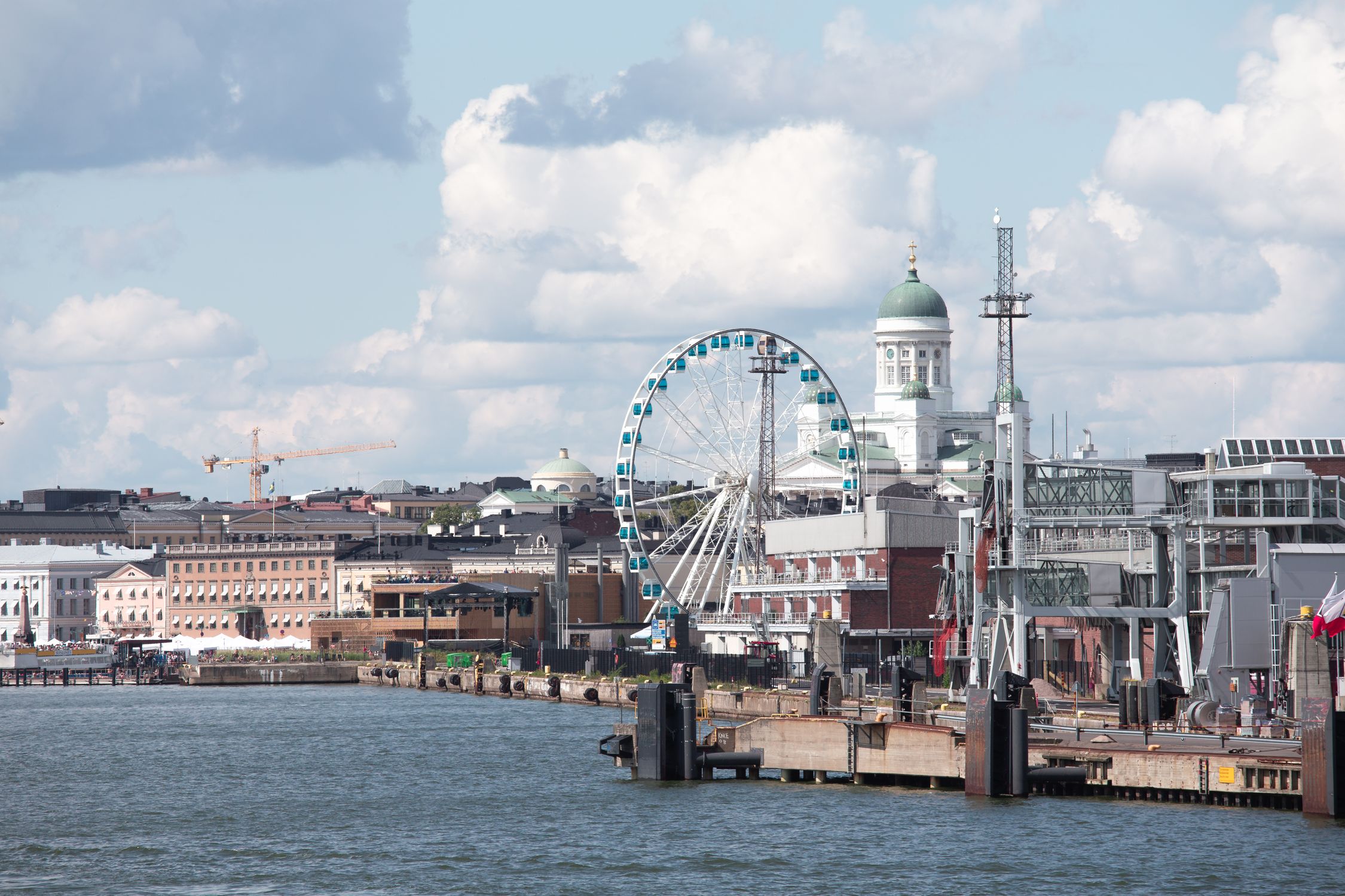 Scenic Helsinki waterfront featuring the Sky Wheel and iconic Helsinki Cathedral.