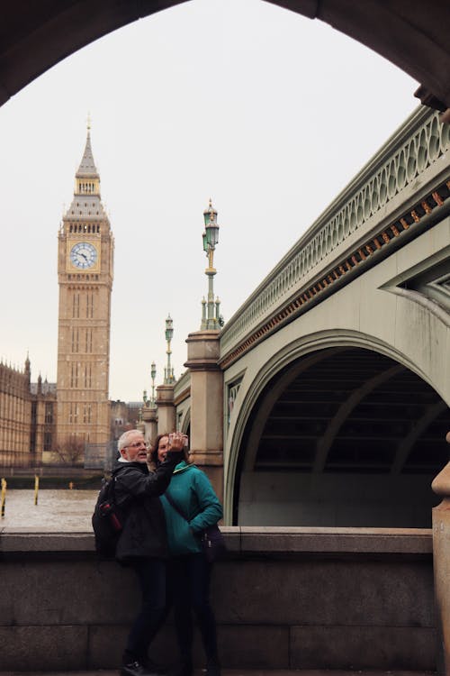 Tourists Standing by Wall near Thames with Big Ben behind