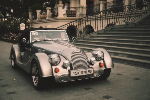 Elegant vintage convertible parked near urban staircase, showcasing classic design and luxury.