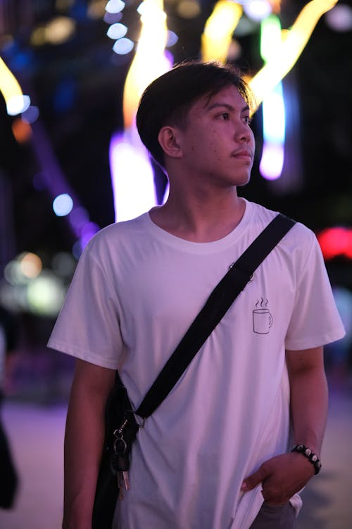 Young Man Standing on the Background of Illuminations 