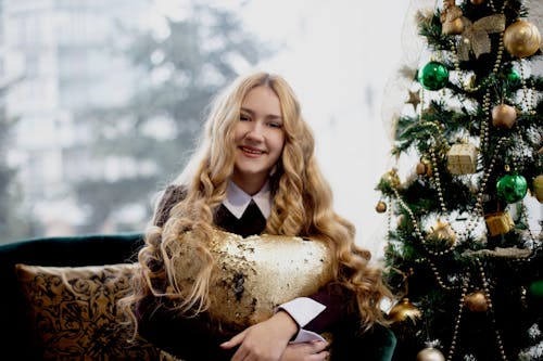 Smiling Woman Sitting Beside Christmas Tree
