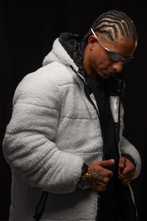 Free Fashionable man in a fluffy hoodie and sunglasses with braided hair in a studio setting. Stock Photo