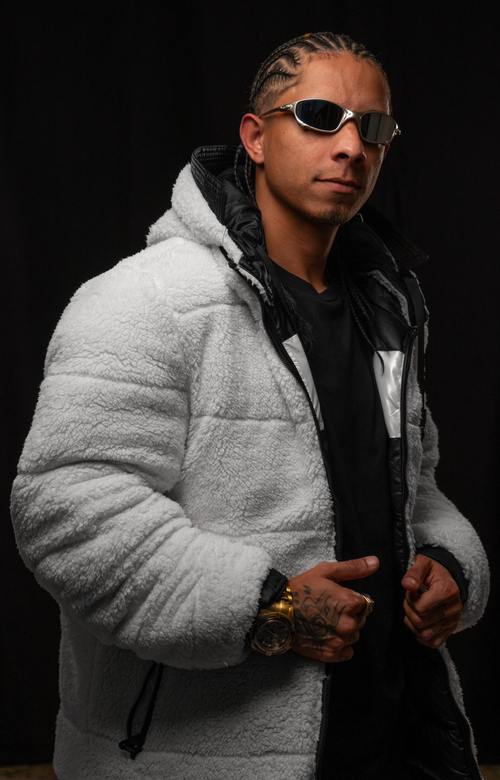 Free Confident man in a white jacket and sunglasses, posing against a black background. Stock Photo