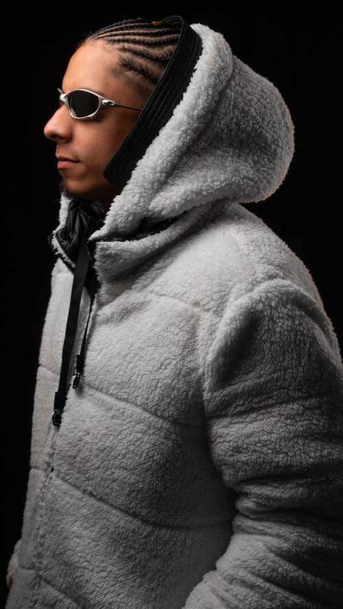 Free Profile of a fashionable man in a cozy white hoodie, wearing sunglasses against a dark backdrop. Stock Photo