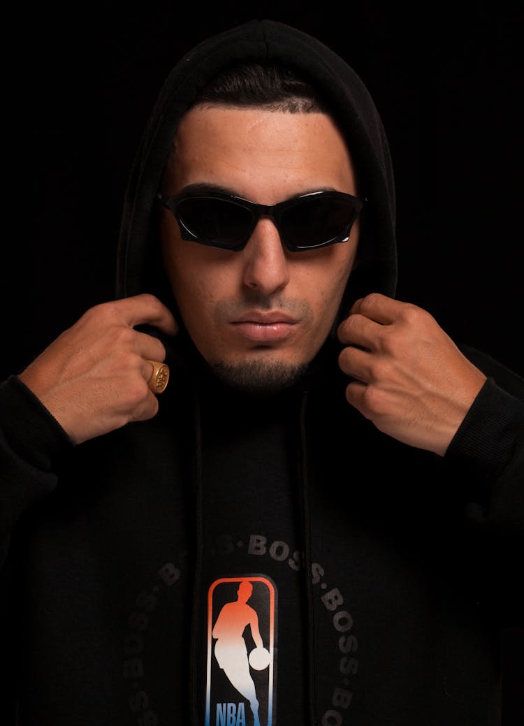 Man In Black Hoodie Sweatshirt Fixing Hood