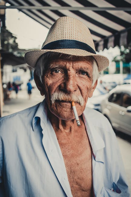Portrait of an elderly man wearing a hat and smoking in São Paulo's streets, Brazil.