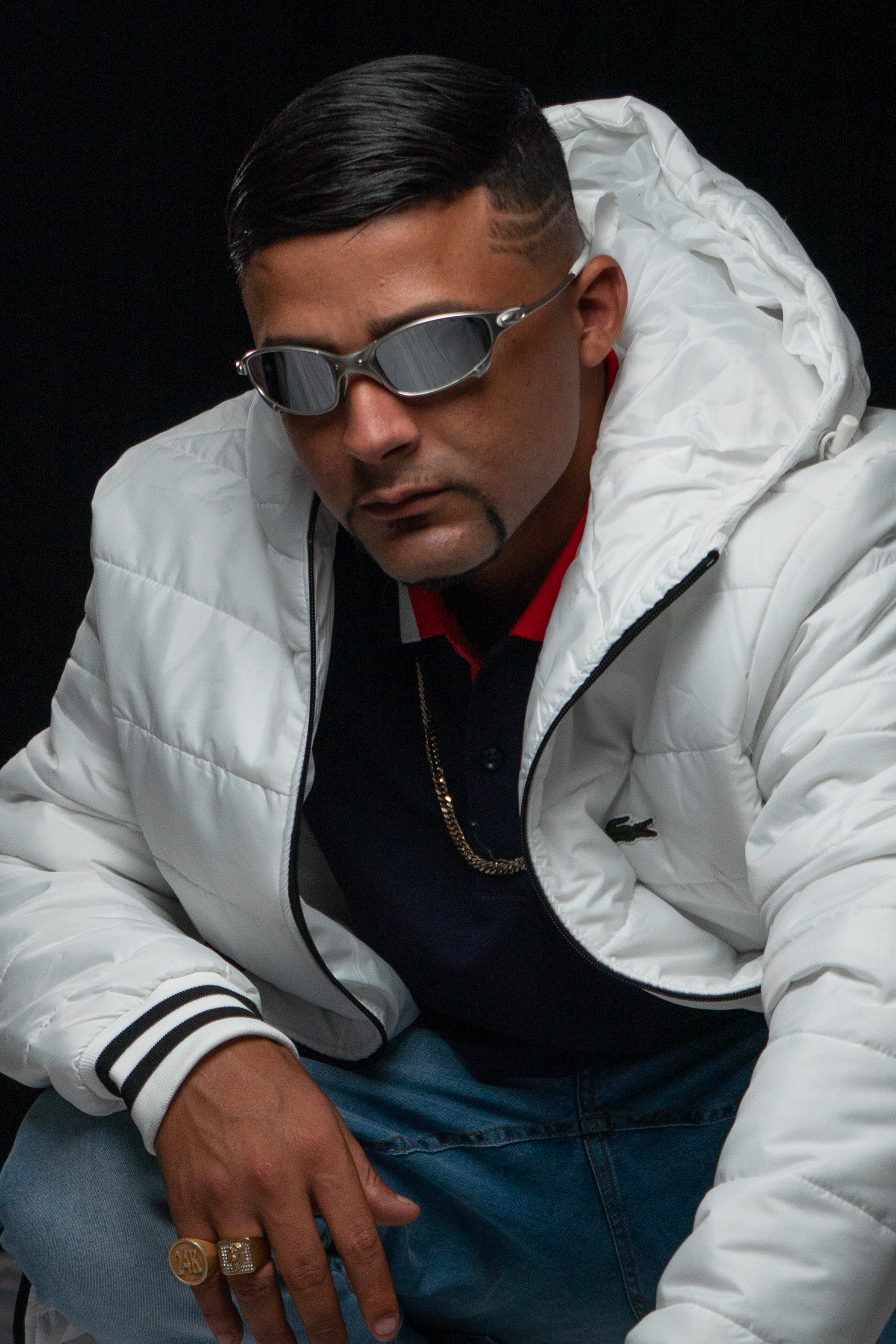 Sharp portrait of a man wearing a white jacket and sunglasses, exuding confidence.