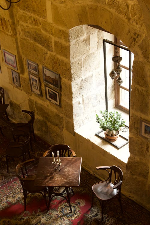 Table and Chair near Window and Stone Wall in Vintage Room