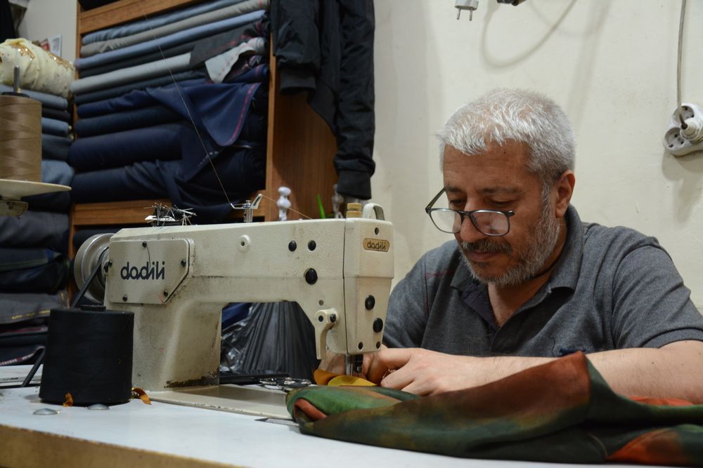 Tailor repairing a garment on the sewing machine