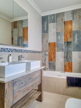 Contemporary bathroom design featuring unique tile patterns, double sinks, and modern fixtures.