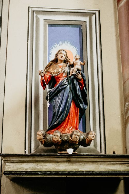 Free A religious statue featuring Virgin Mary holding Christ Child, inside a church setting. Stock Photo