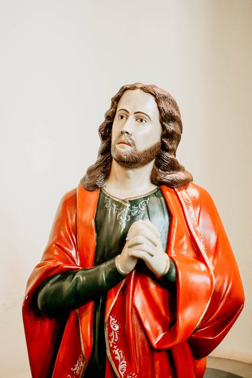 Sculpture of Praying Saint in Red Tunic