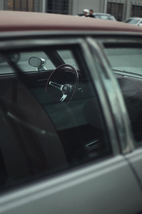 Free Artistic close-up view of a vintage car's interior seen through the window in an urban setting. Stock Photo