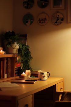 A warm, inviting home workspace with candles and a mug creating a cozy atmosphere.